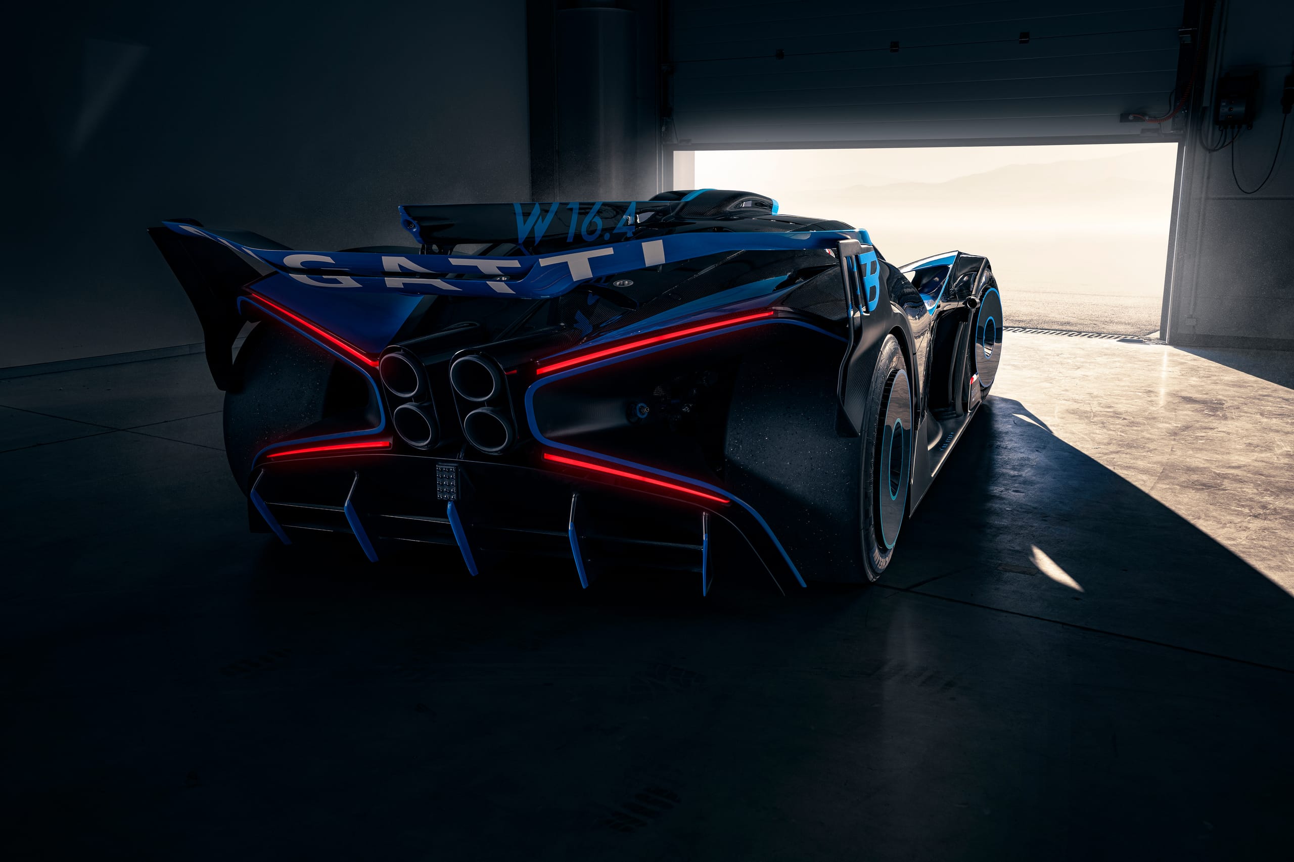 Rear three-quarter view of Bugatti Bolide showing rear wing, triple-layer diffuser, and red LED light accents