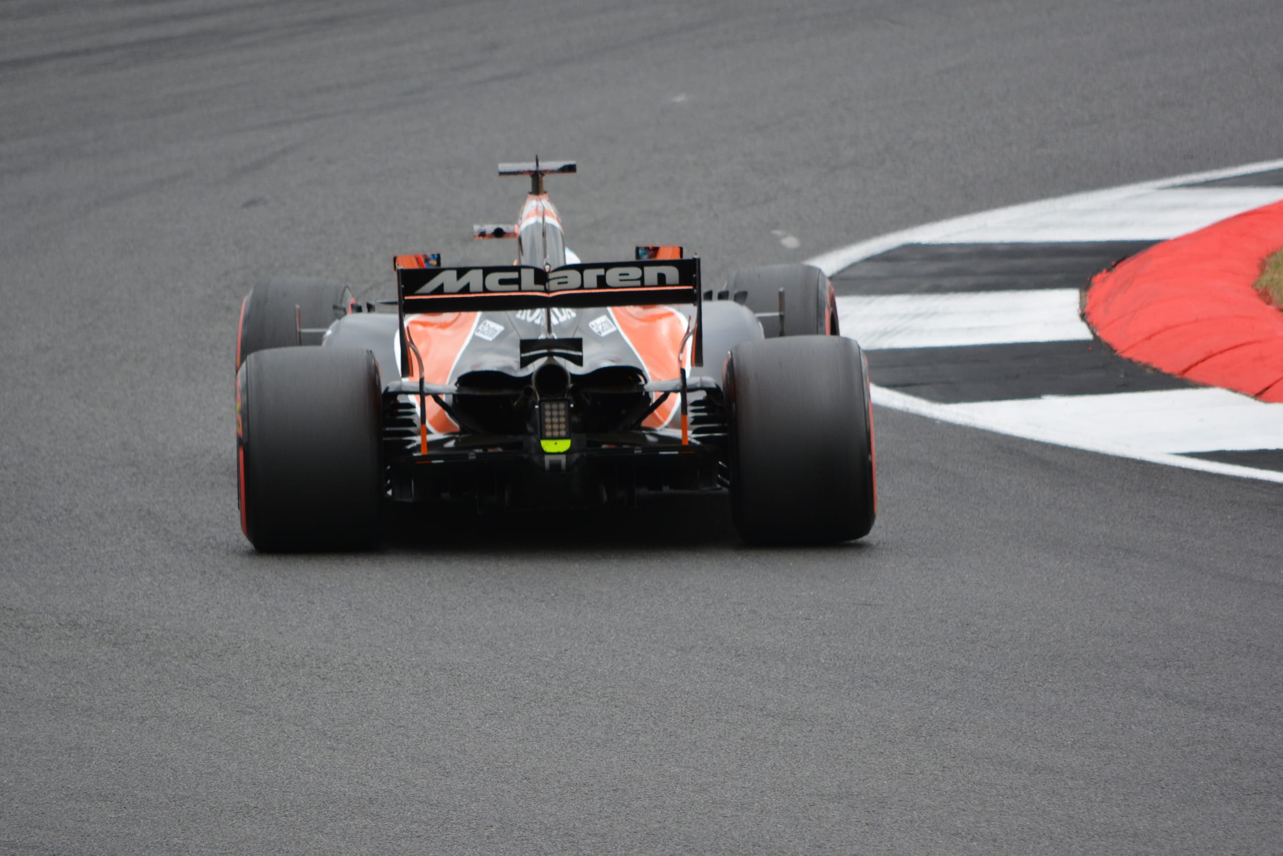 Rear view of a McLaren F1 car on circuit, illustrating the neutral chassis layout with a centred CoM