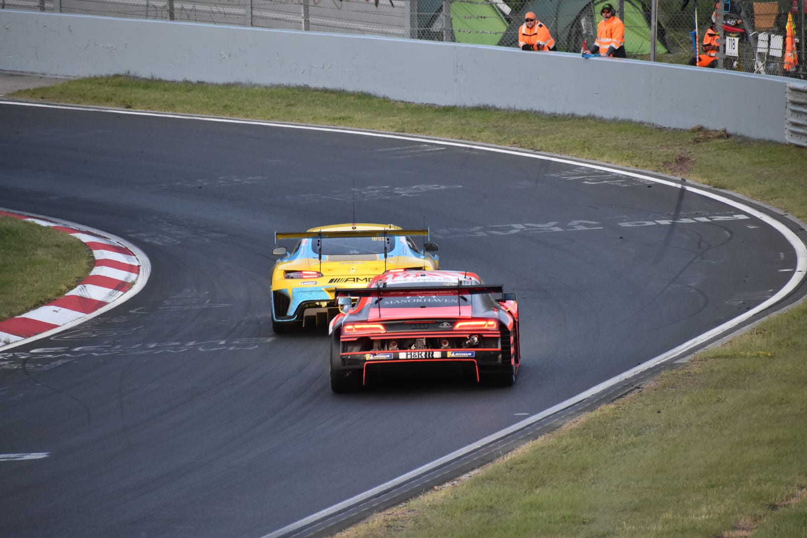 Two GT3 cars cornering line astern past marshal posts