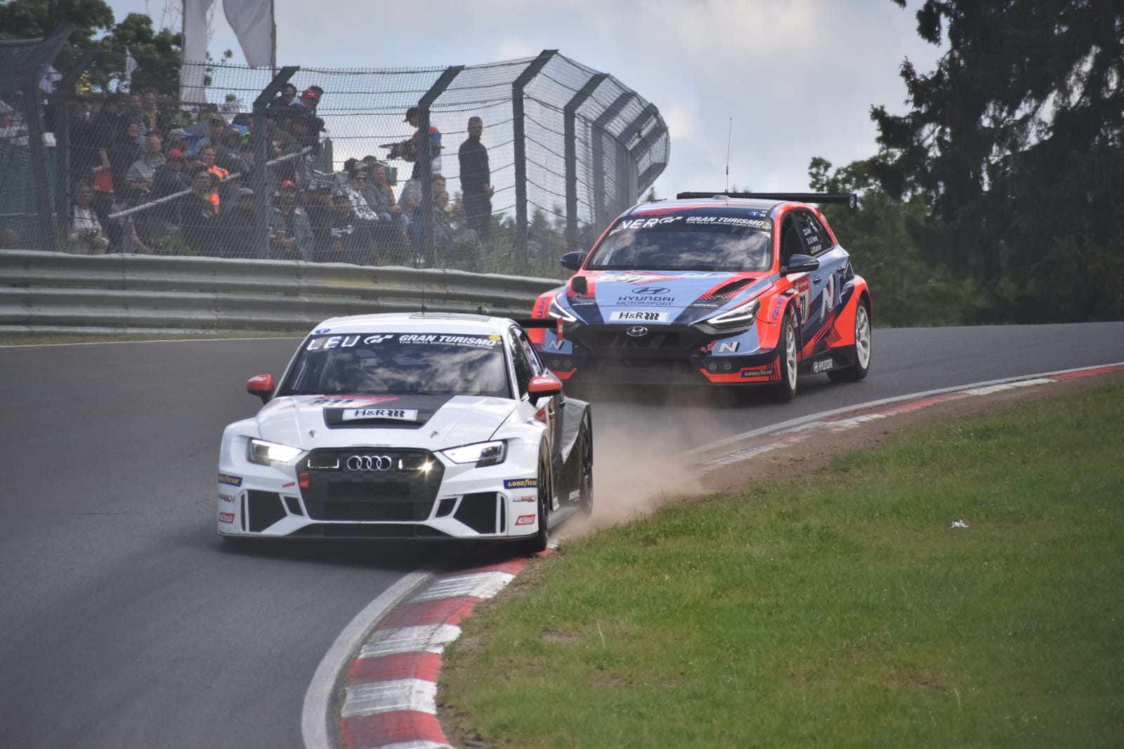 Front-wheel-drive TCR cars — an Audi RS3 LMS and a Hyundai — cornering on the Nürburgring Nordschleife